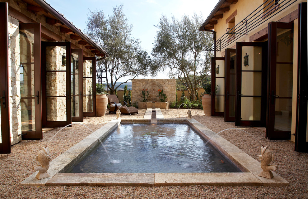 Photo of a large mediterranean back rectangular natural swimming pool in Los Angeles with natural stone paving.