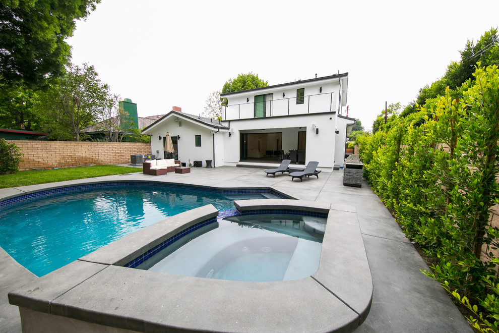 Moderner Pool hinter dem Haus in individueller Form mit Betonplatten in Los Angeles