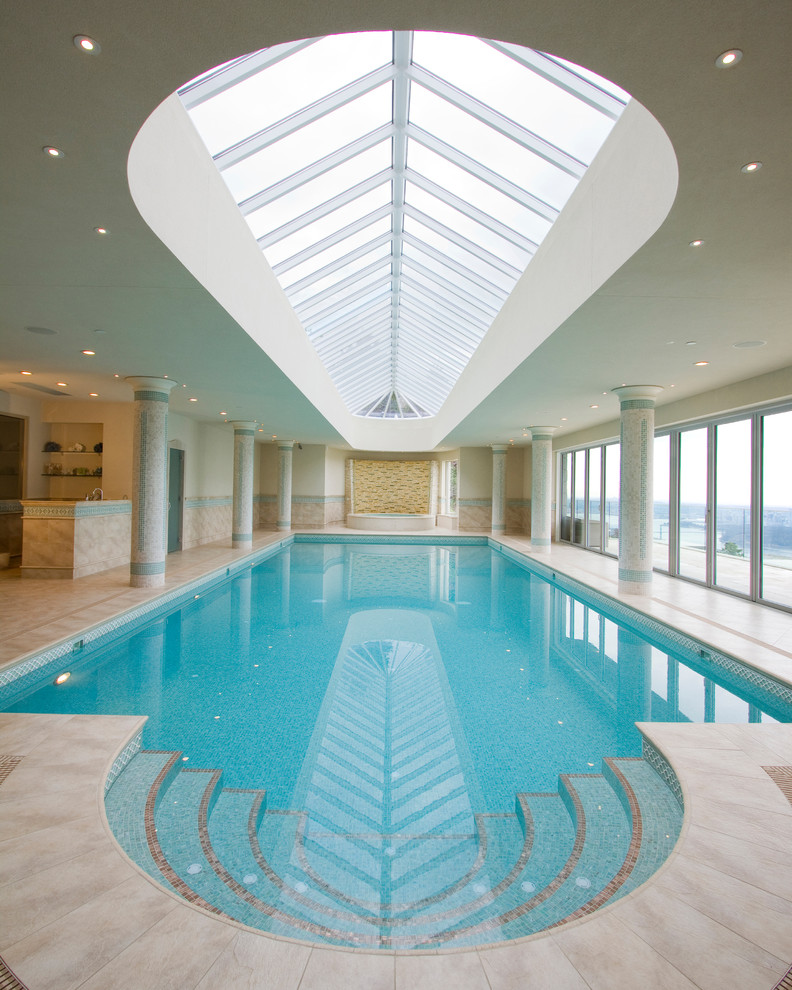 Photo of an expansive contemporary custom shaped swimming pool in Vancouver with tiled flooring.
