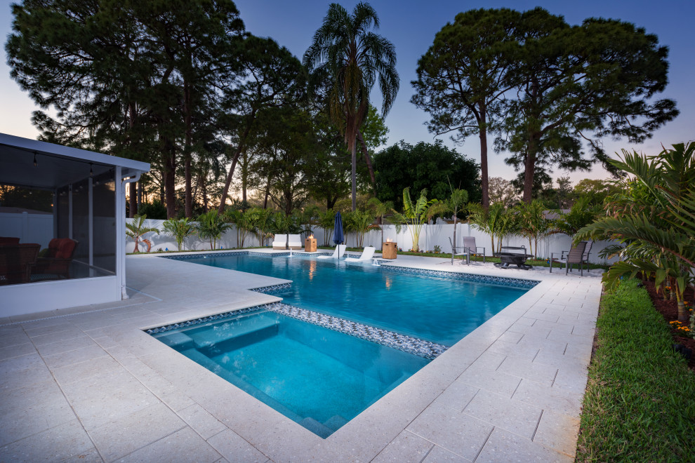 Modelo de piscinas y jacuzzis alargados minimalistas grandes rectangulares en patio trasero con suelo de baldosas