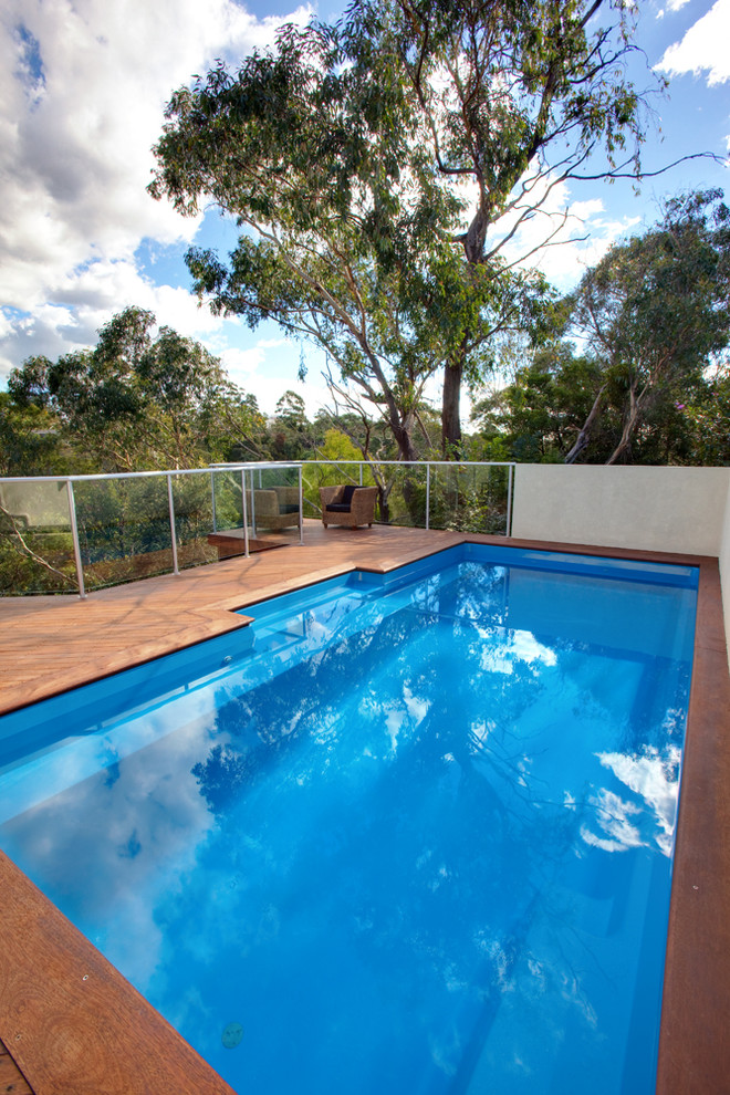 Medium sized rustic side rectangular above ground swimming pool in Sydney with decking.