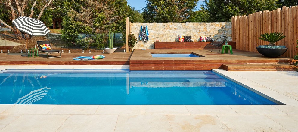 Immagine di una grande piscina monocorsia stile marino rettangolare dietro casa con una vasca idromassaggio e pedane