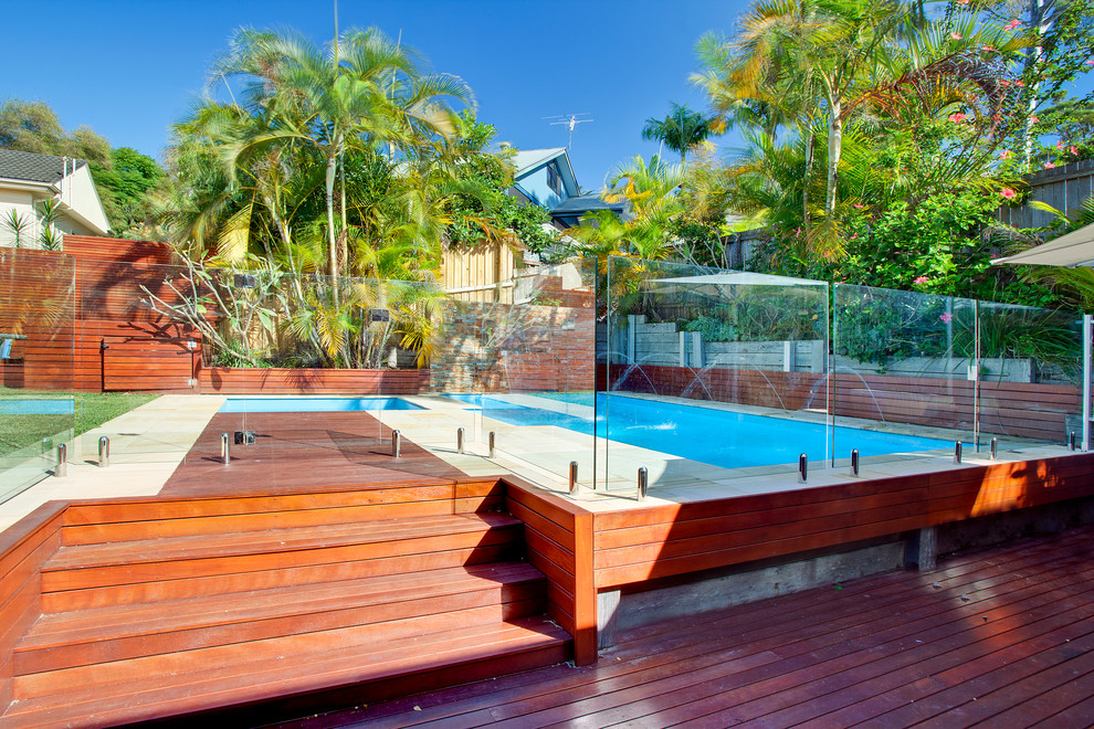 Идея дизайна: прямоугольный бассейн среднего размера на заднем дворе в морском стиле с фонтаном и настилом