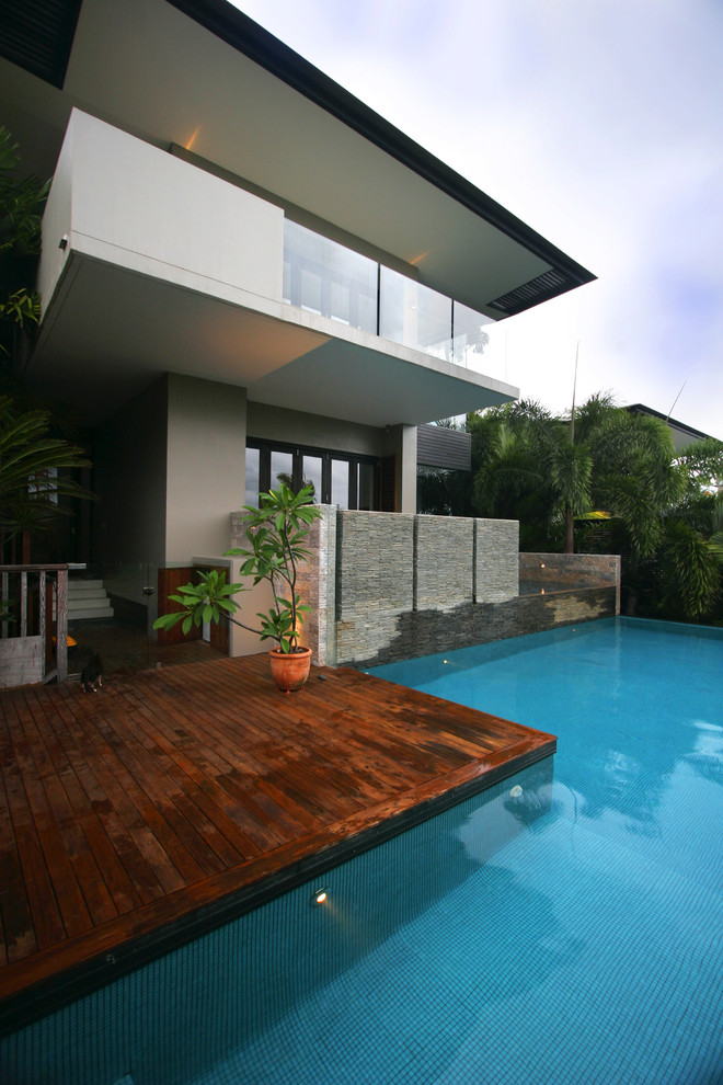 Идея дизайна: бассейн произвольной формы на заднем дворе в современном стиле с настилом