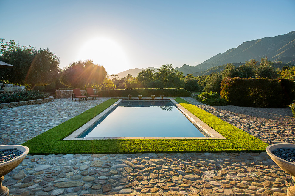 Immagine di una piscina monocorsia chic rettangolare dietro casa con piastrelle