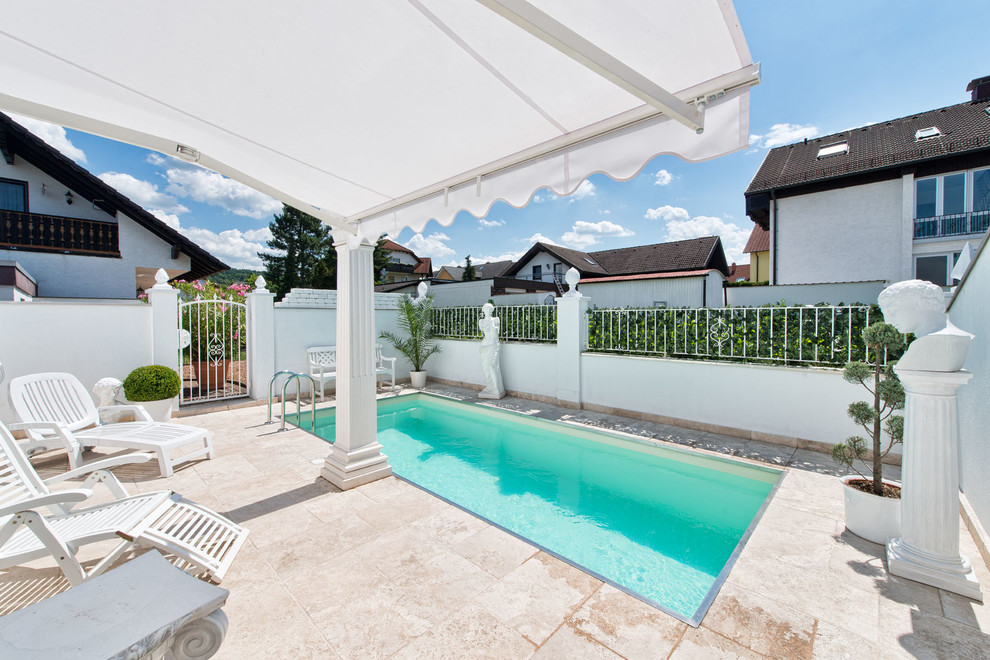 Foto de piscina alargada clásica pequeña rectangular en patio con adoquines de piedra natural