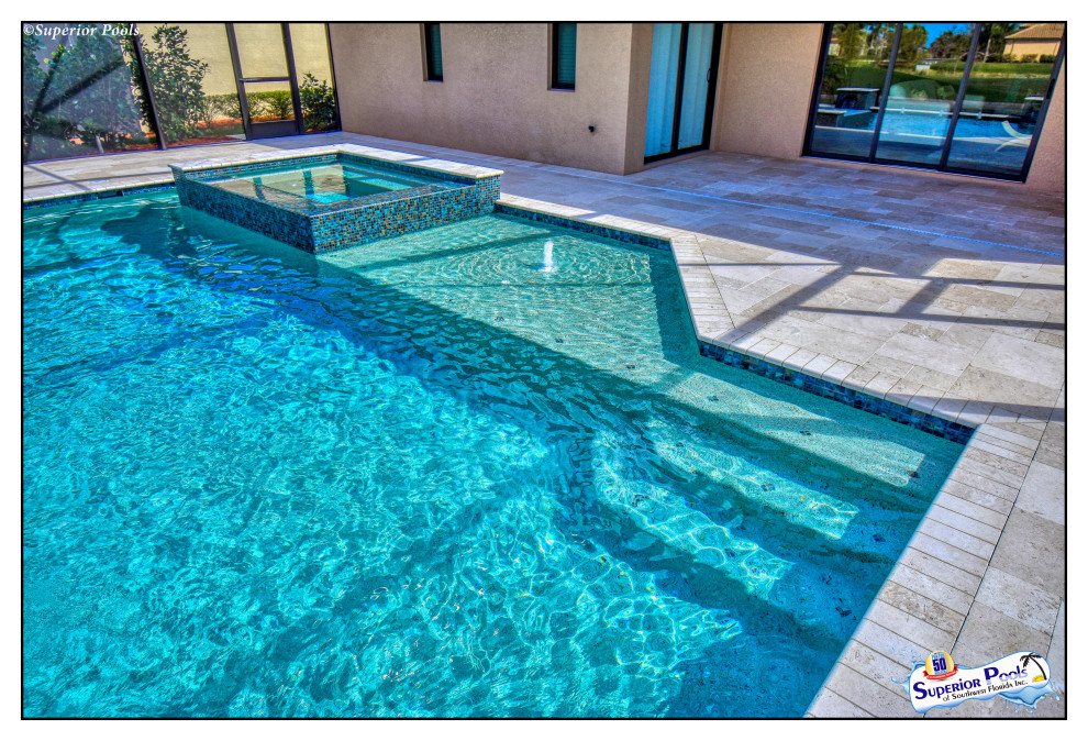 Foto de piscina con fuente clásica de tamaño medio rectangular en patio trasero con adoquines de piedra natural