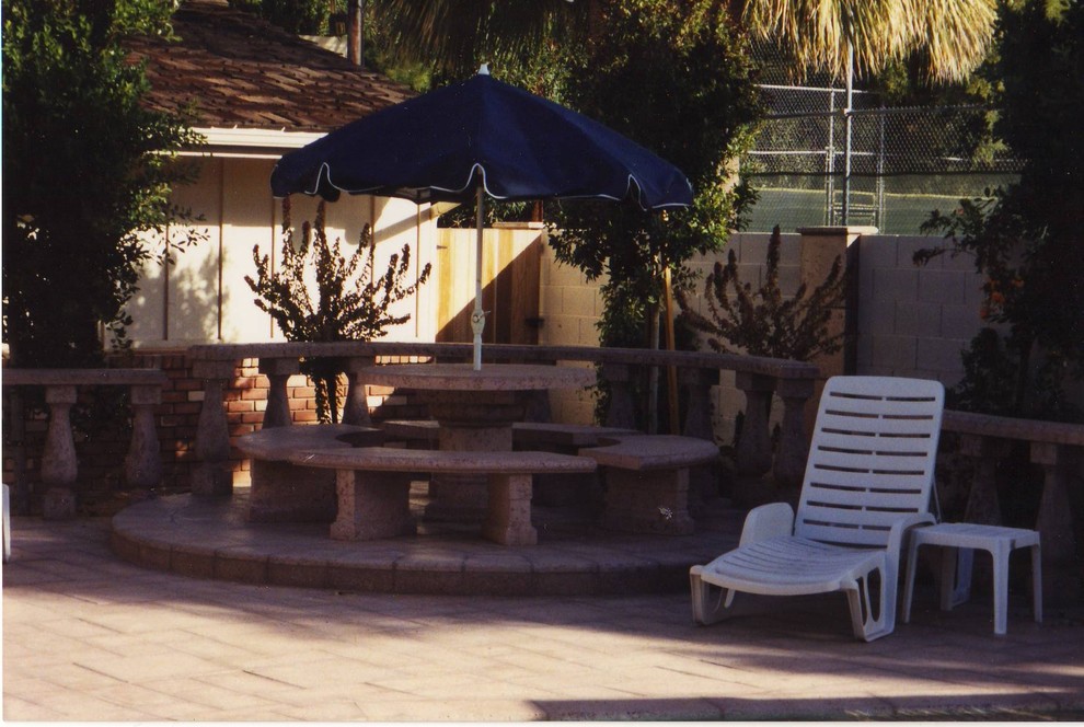 Ejemplo de piscina tradicional rectangular en patio trasero con adoquines de piedra natural