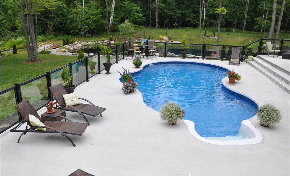Пример оригинального дизайна: маленький бассейн в форме фасоли на заднем дворе в стиле неоклассика (современная классика) с покрытием из бетонных плит для на участке и в саду