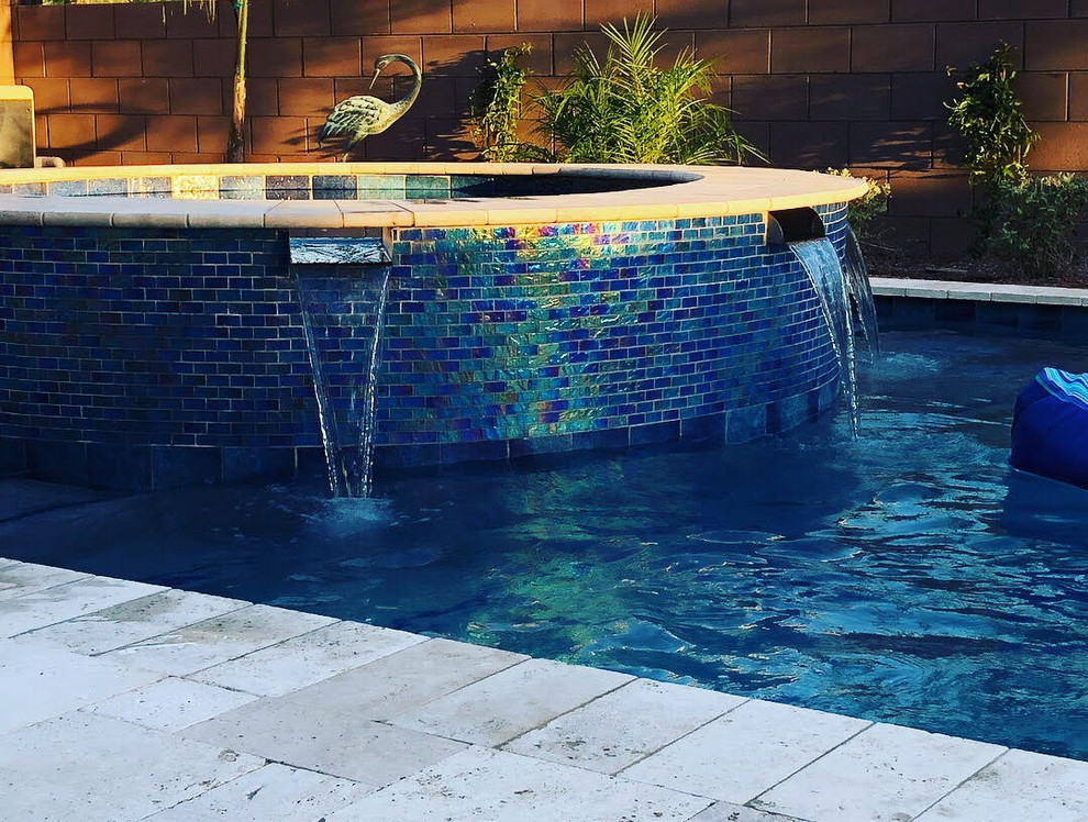 На фото: круглый бассейн среднего размера на заднем дворе в стиле модернизм с джакузи и покрытием из каменной брусчатки с