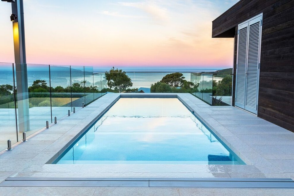 Immagine di una piscina design rettangolare di medie dimensioni e nel cortile laterale con piastrelle