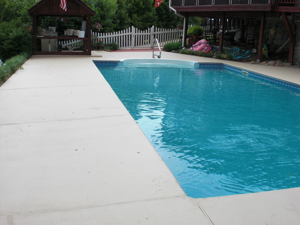 Пример оригинального дизайна: прямоугольный бассейн на заднем дворе в классическом стиле с покрытием из бетонных плит