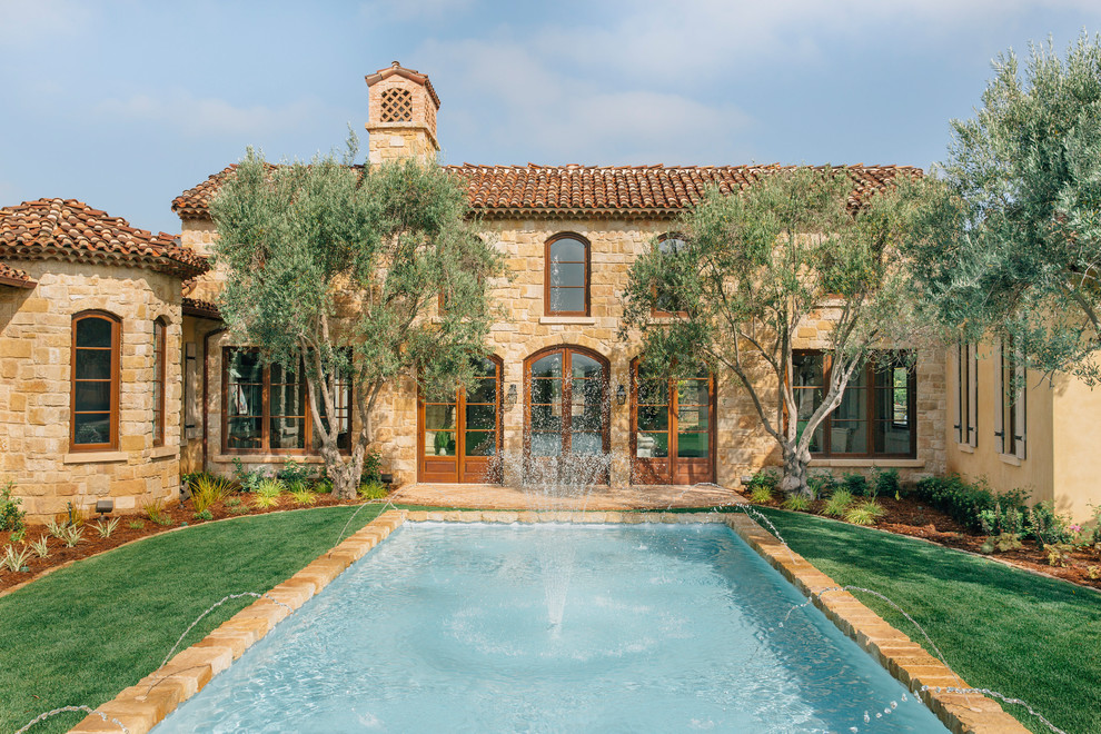 Mediterranes Sportbecken hinter dem Haus in rechteckiger Form mit Wasserspiel und Pflastersteinen in San Diego
