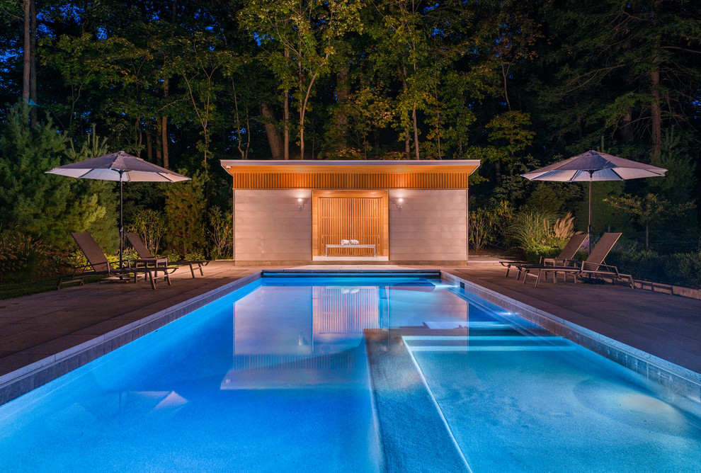 Diseño de casa de la piscina y piscina alargada tradicional renovada pequeña rectangular en patio trasero con adoquines de hormigón