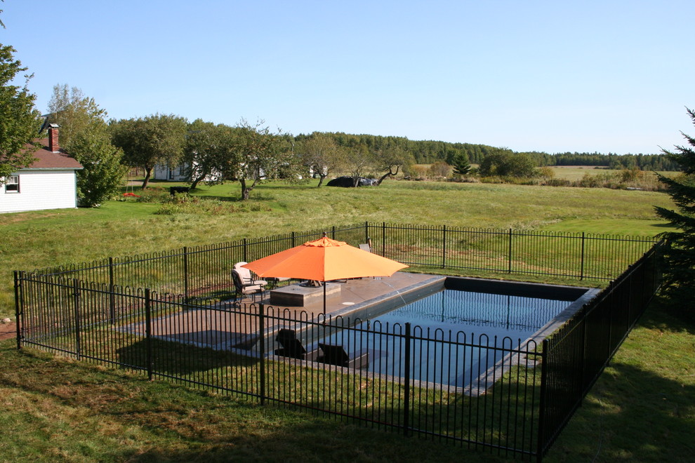 Esempio di una piscina tradizionale rettangolare di medie dimensioni e dietro casa con cemento stampato