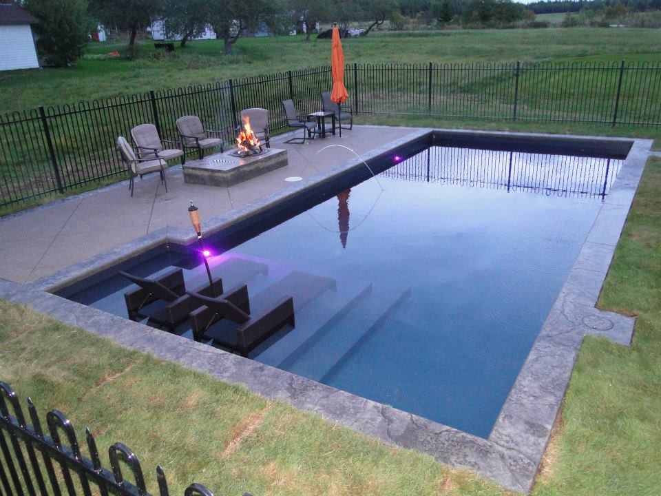 Example of a mid-sized classic backyard stamped concrete and rectangular pool design in Other