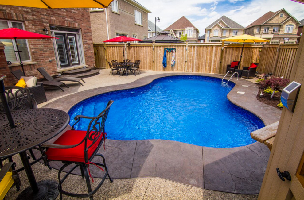 Immagine di una piscina classica di medie dimensioni e dietro casa con cemento stampato