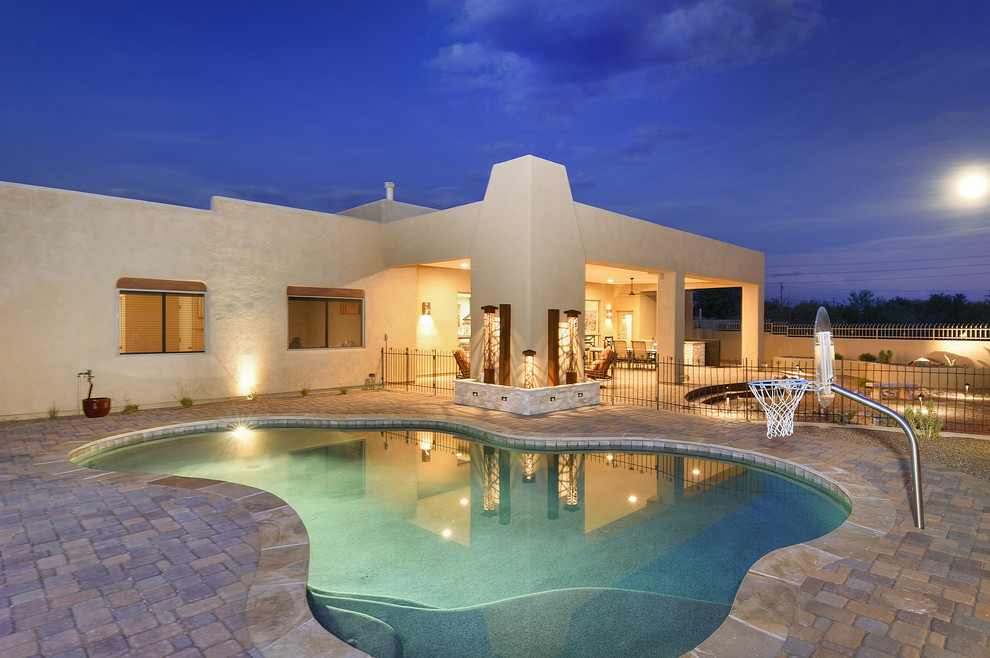 Immagine di una piscina stile americano personalizzata di medie dimensioni e dietro casa con pavimentazioni in cemento e paesaggistica bordo piscina