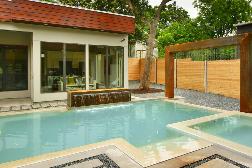 Idee per una grande piscina a sfioro infinito minimalista personalizzata dietro casa con fontane e pavimentazioni in pietra naturale