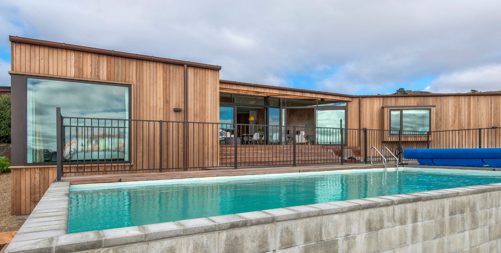 Ispirazione per una piscina design rettangolare di medie dimensioni e davanti casa con pavimentazioni in cemento