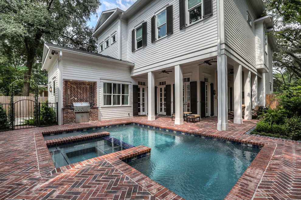 Large elegant backyard brick and rectangular hot tub photo in Houston