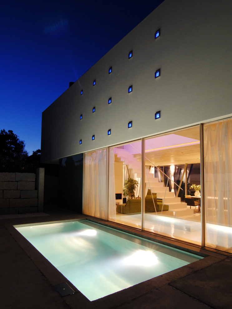 Esempio di una piscina monocorsia contemporanea rettangolare di medie dimensioni e nel cortile laterale con lastre di cemento