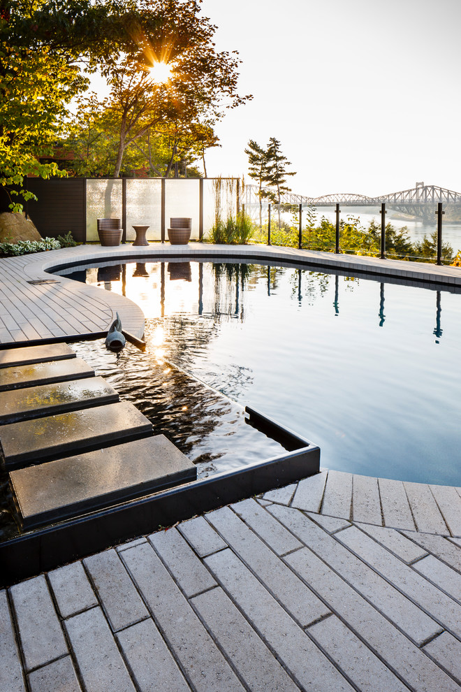 Ispirazione per una piscina monocorsia chic rotonda di medie dimensioni e dietro casa con pavimentazioni in pietra naturale