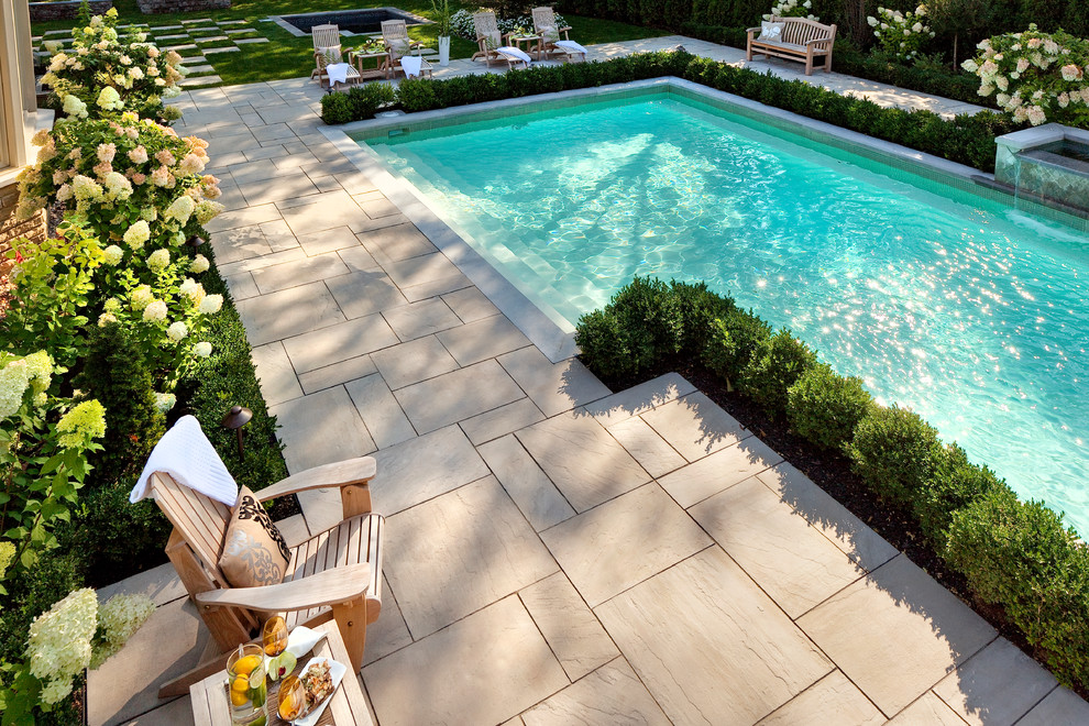 Diseño de piscina alargada clásica renovada grande rectangular en patio trasero con suelo de hormigón estampado