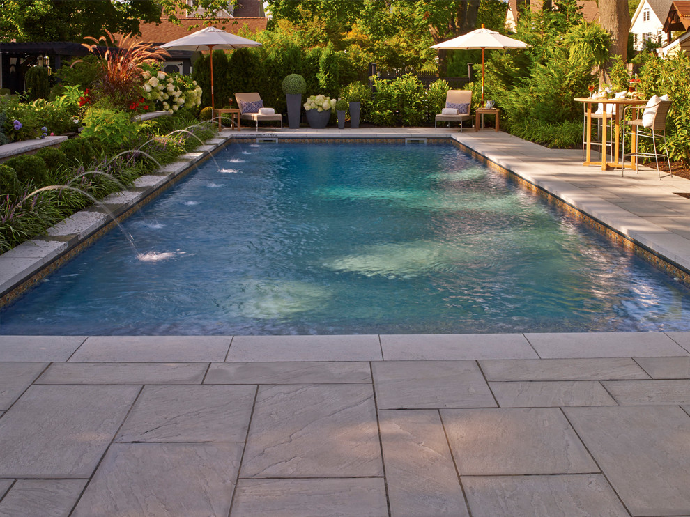 Foto di una piccola piscina naturale tradizionale rettangolare dietro casa con fontane e pavimentazioni in pietra naturale