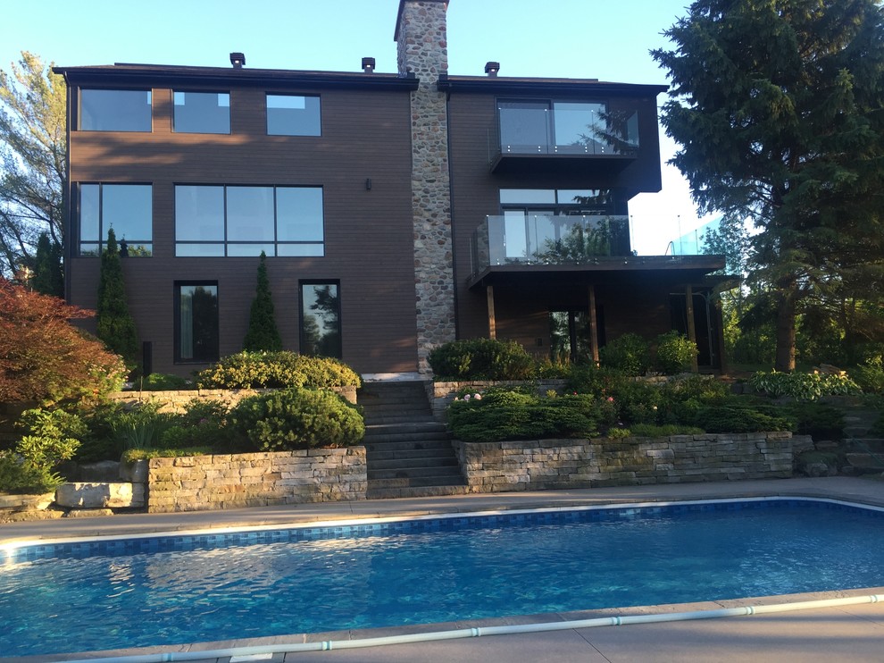 Пример оригинального дизайна: прямоугольный бассейн среднего размера на заднем дворе в стиле модернизм с покрытием из каменной брусчатки