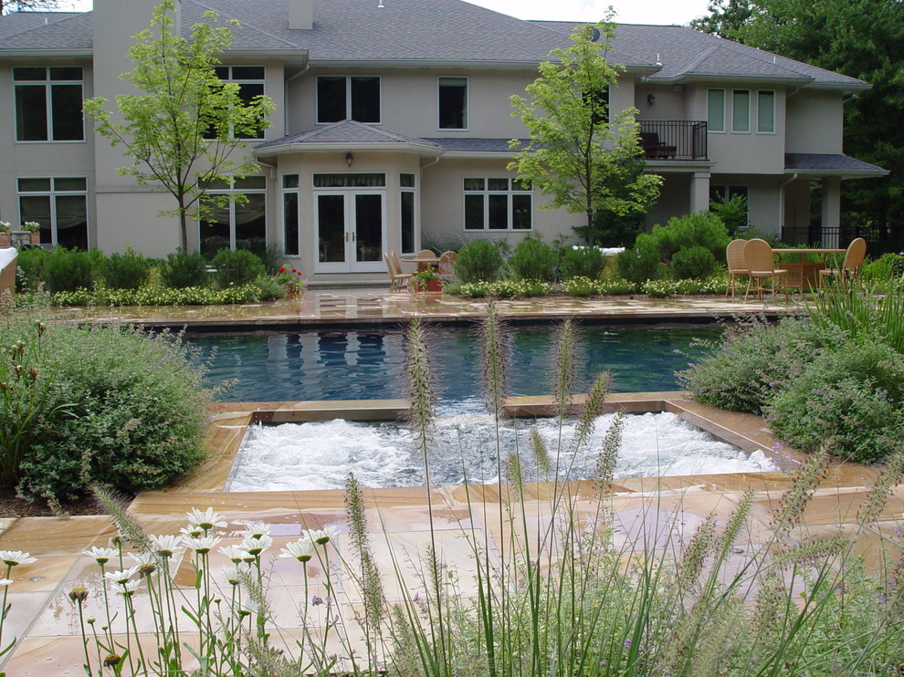 Modelo de piscina con fuente alargada mediterránea grande rectangular en patio trasero con adoquines de piedra natural
