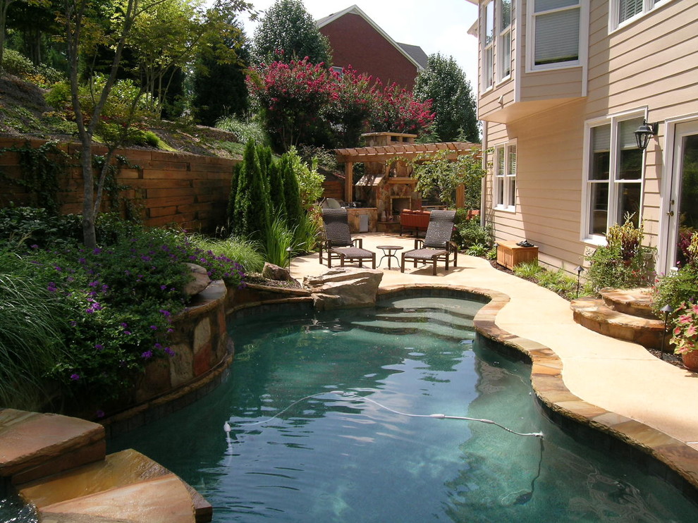 Large traditional back custom shaped lengths swimming pool in Atlanta with natural stone paving.