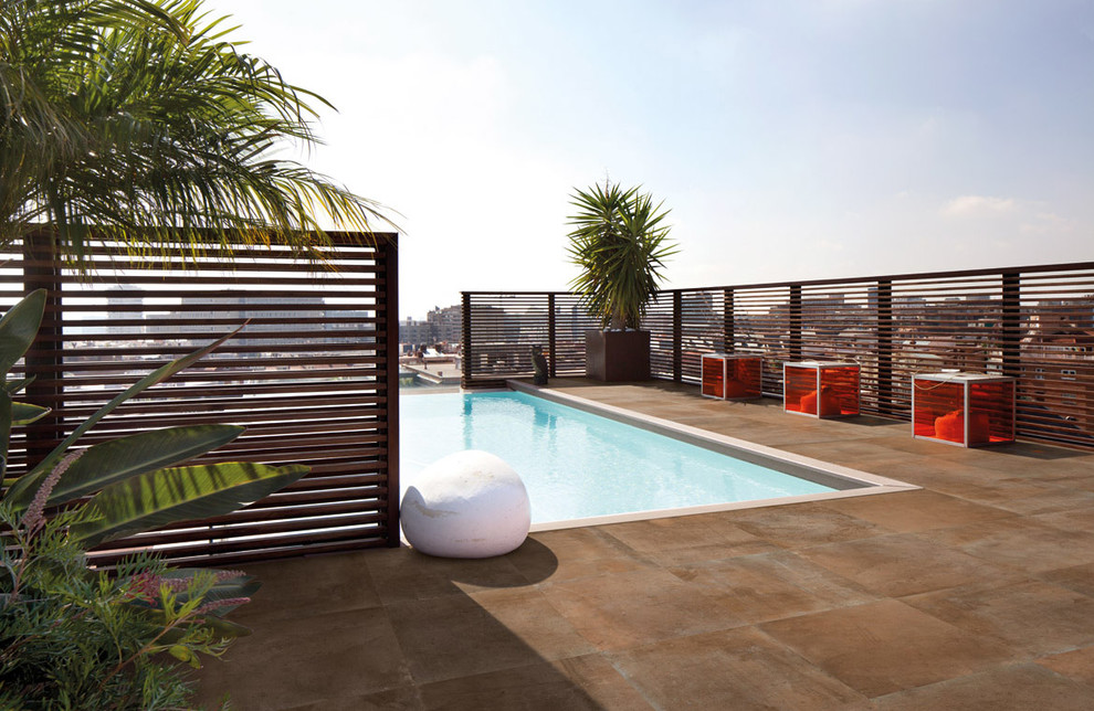 Diseño de piscina alargada actual de tamaño medio rectangular en azotea con suelo de baldosas