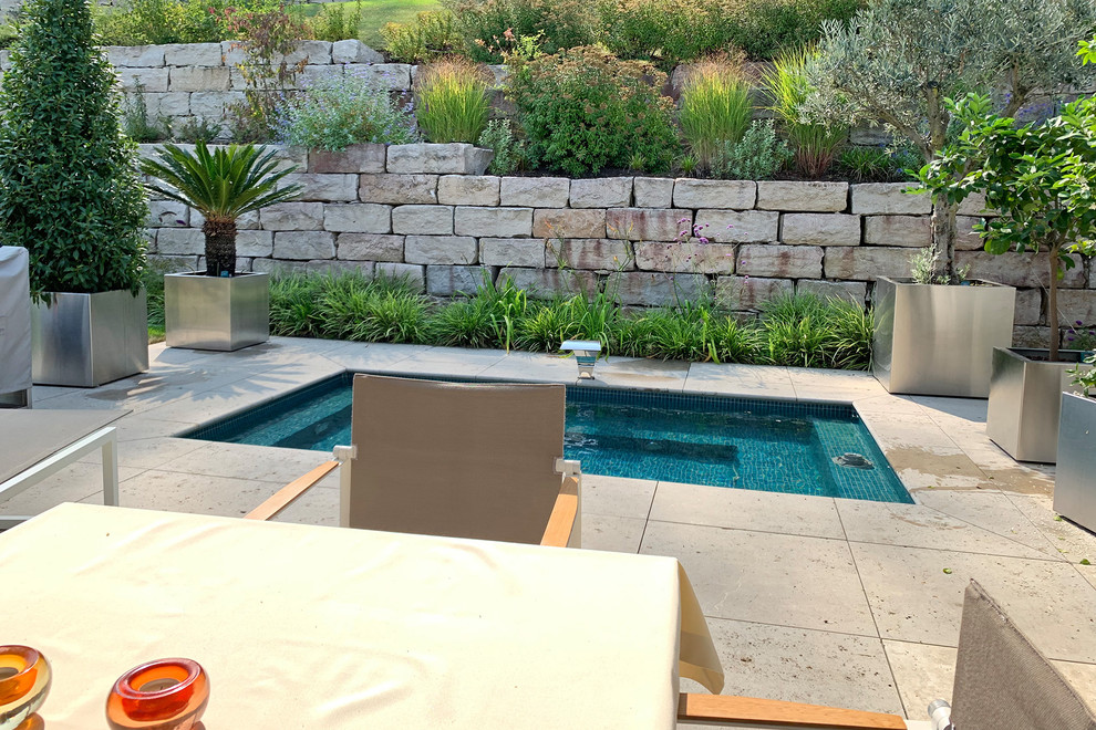 Foto de piscina elevada contemporánea pequeña rectangular en patio lateral con adoquines de piedra natural