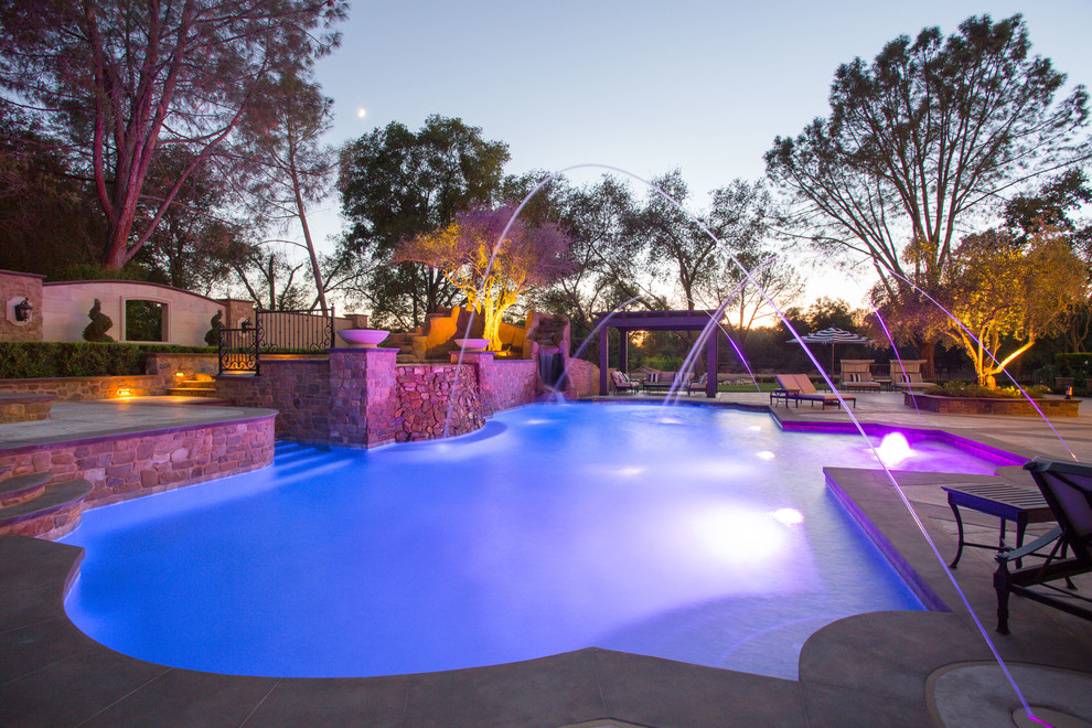 Pool - huge traditional backyard stamped concrete pool idea in Sacramento