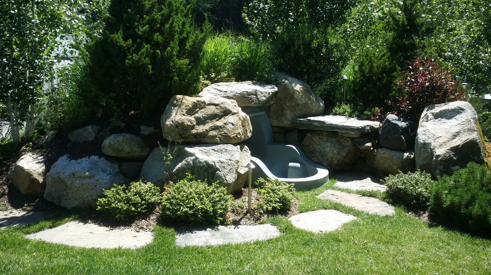 Imagen de casa de la piscina y piscina alargada clásica grande rectangular en patio trasero con adoquines de piedra natural