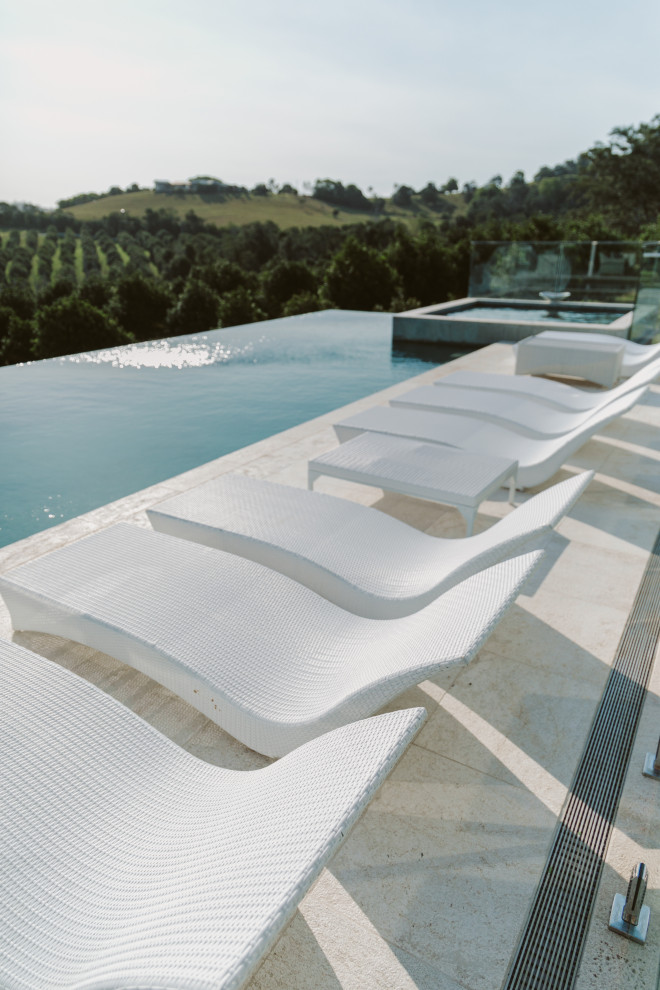 Foto di una piscina fuori terra design rettangolare di medie dimensioni e sul tetto con una vasca idromassaggio e pavimentazioni in pietra naturale