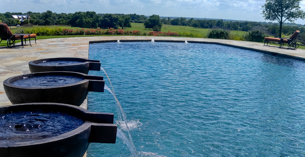 Photo of a large classic back rectangular lengths swimming pool in Dallas with a water feature and natural stone paving.