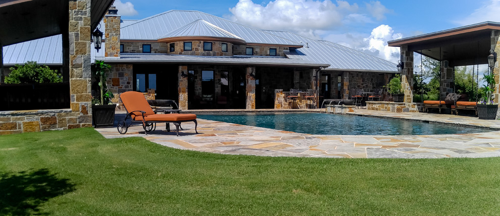Idee per una grande piscina monocorsia tradizionale rettangolare dietro casa con fontane e pavimentazioni in pietra naturale