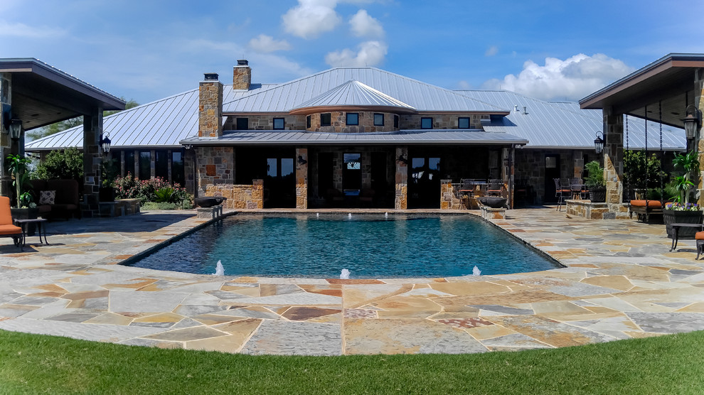 Großes Klassisches Sportbecken hinter dem Haus in rechteckiger Form mit Wasserspiel und Natursteinplatten in Dallas