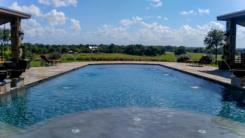 На фото: большой спортивный, прямоугольный бассейн на заднем дворе в классическом стиле с фонтаном и покрытием из каменной брусчатки с