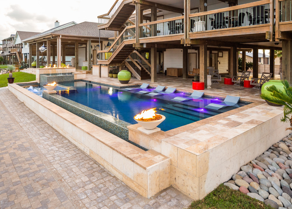 Foto di una piscina design rettangolare di medie dimensioni e dietro casa con una vasca idromassaggio e piastrelle