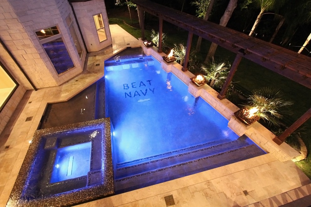 На фото: большой бассейн-инфинити произвольной формы на заднем дворе в стиле неоклассика (современная классика) с джакузи и покрытием из каменной брусчатки с