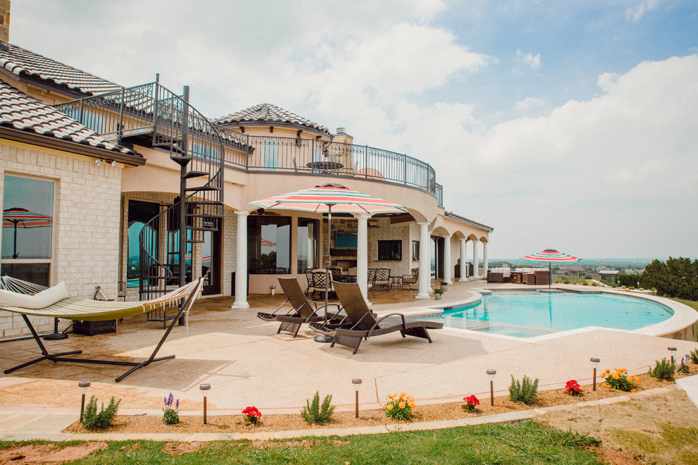Imagen de piscinas y jacuzzis mediterráneos grandes a medida en patio trasero con losas de hormigón