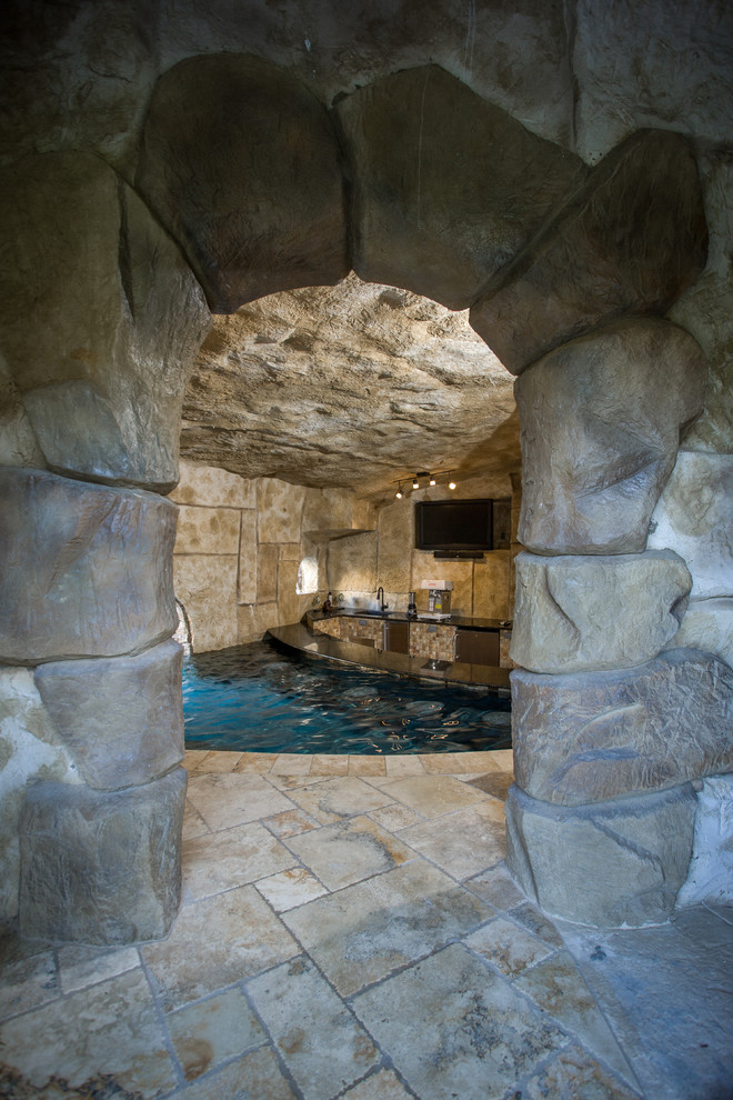 This is an example of an expansive traditional back custom shaped hot tub in Houston with natural stone paving.