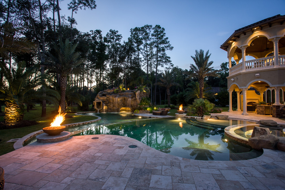 Inspiration for an expansive mediterranean back custom shaped hot tub in Houston with natural stone paving.