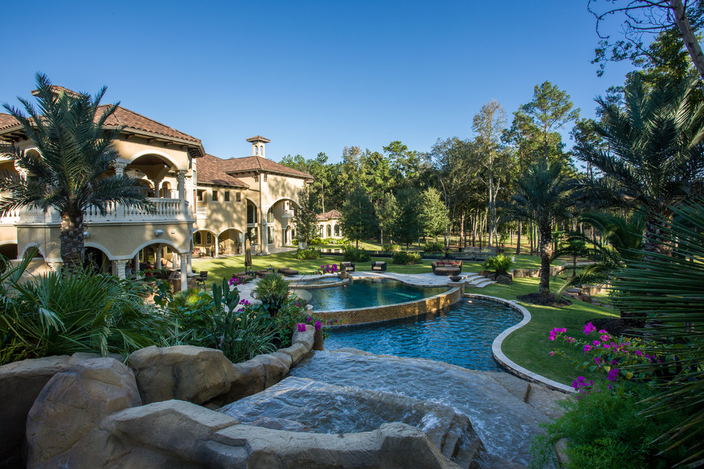 Diseño de piscinas y jacuzzis mediterráneos extra grandes a medida en patio trasero con adoquines de piedra natural