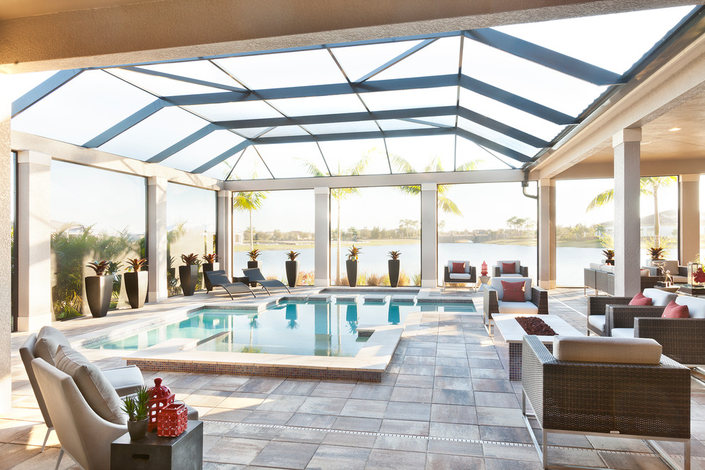 Foto de piscina con fuente actual grande rectangular en patio trasero con adoquines de hormigón