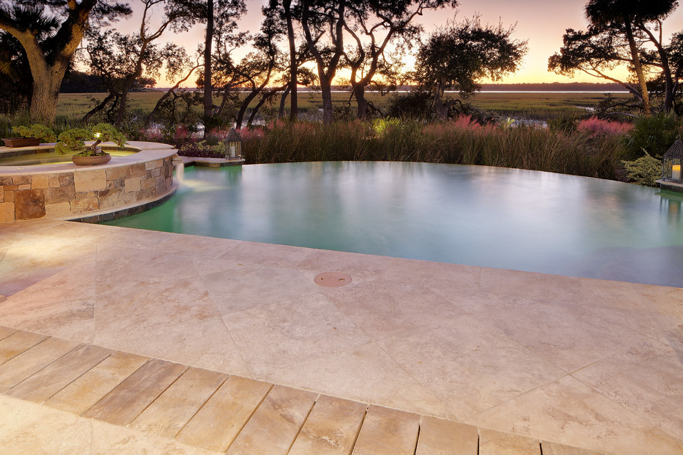 Imagen de piscinas y jacuzzis infinitos contemporáneos grandes a medida en patio trasero con adoquines de piedra natural