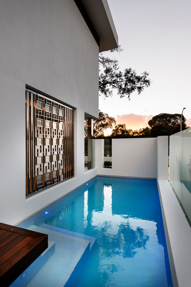 Foto de piscina contemporánea en forma de L en patio lateral con entablado